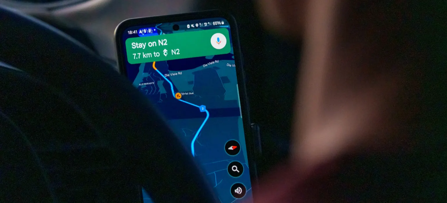 Person using navigation app on smartphone inside car